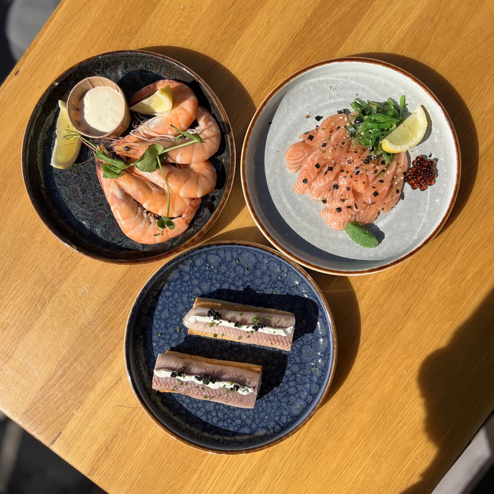 Zeewaar en sashimi gerechten op houten tafel.